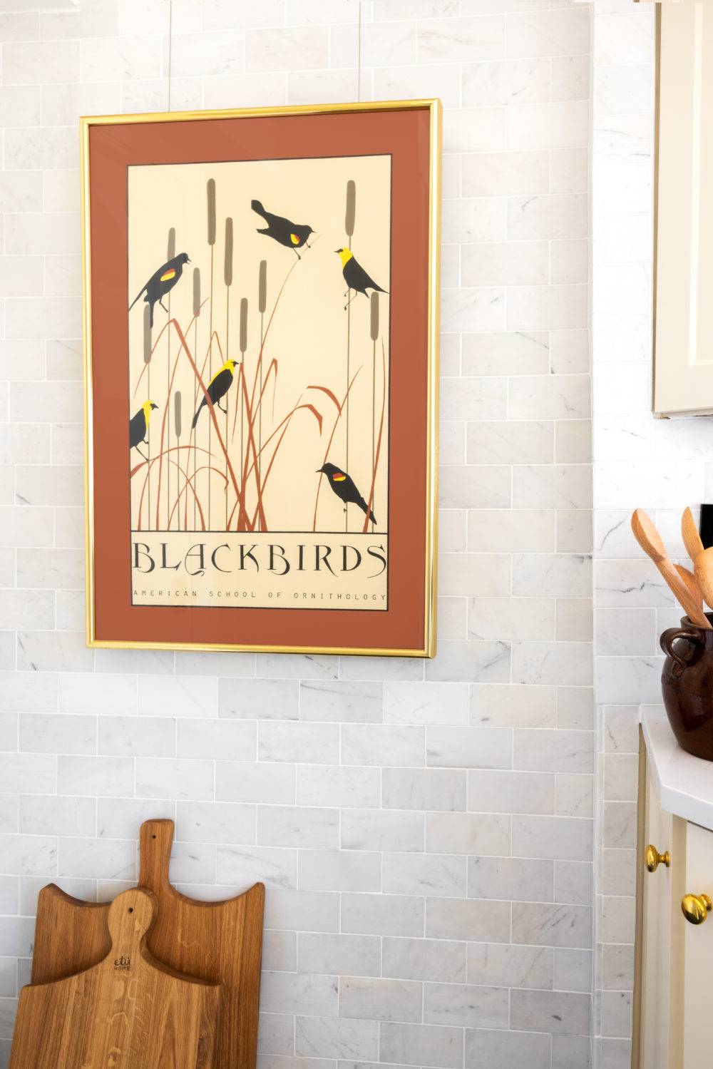 detail shot of kitchen with white marble subway tile with a blackbirds print