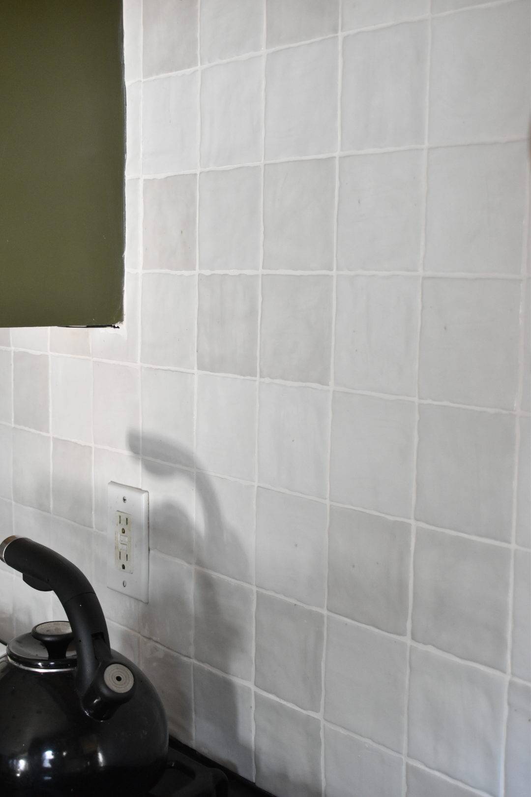 Detail shot of white handmade-look tile kitchen backsplash