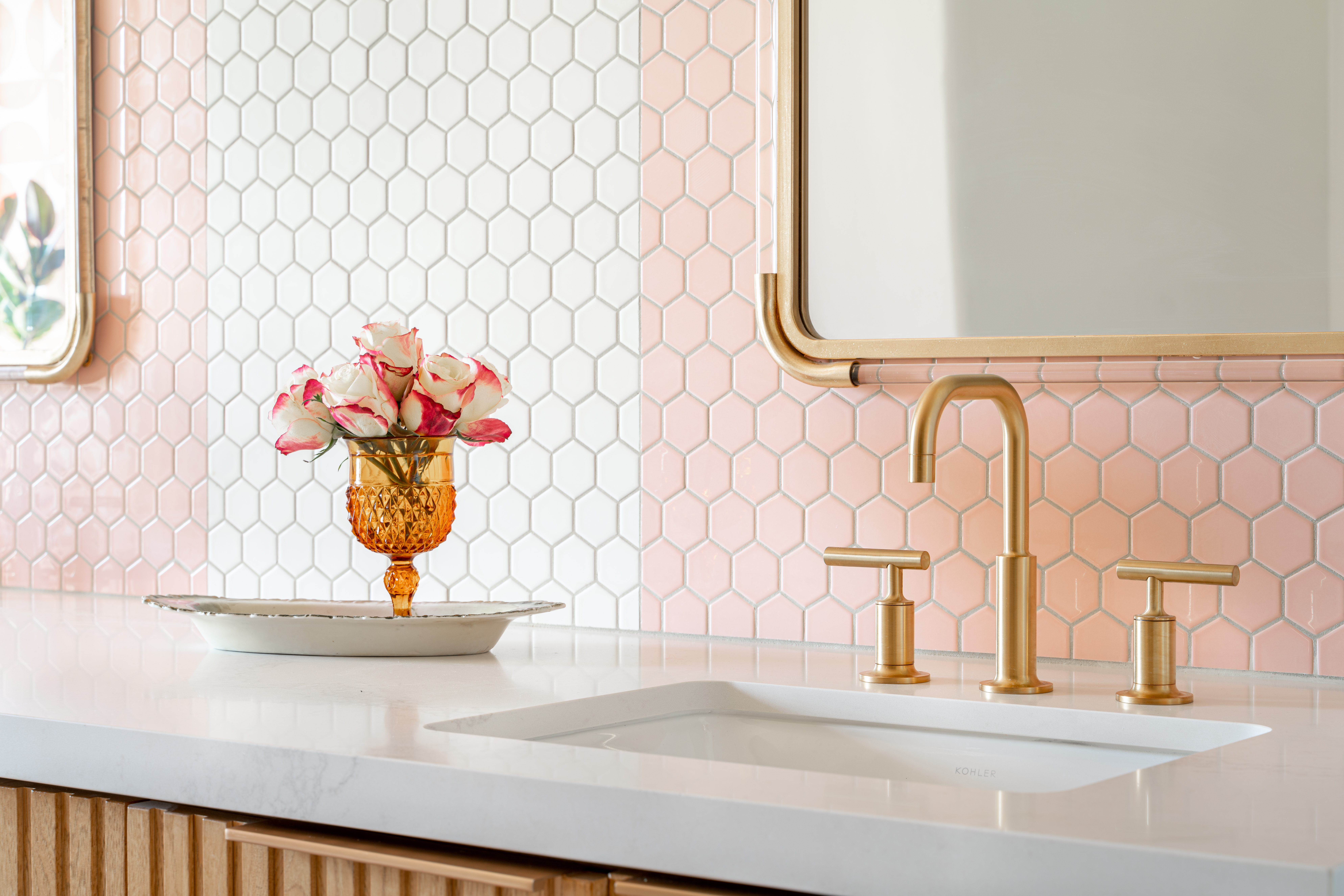 detail shot of bathroom vanity with white hex tiled backsplash and pink tiled arches