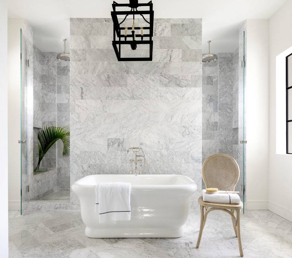 Luxurious white marble bathroom with large walk in shower and freestanding tub