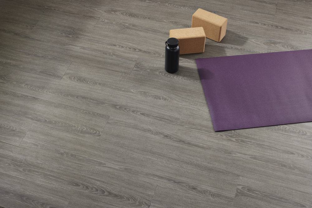 purple yoga mat and water bottle sitting on grey vinyl plank flooring