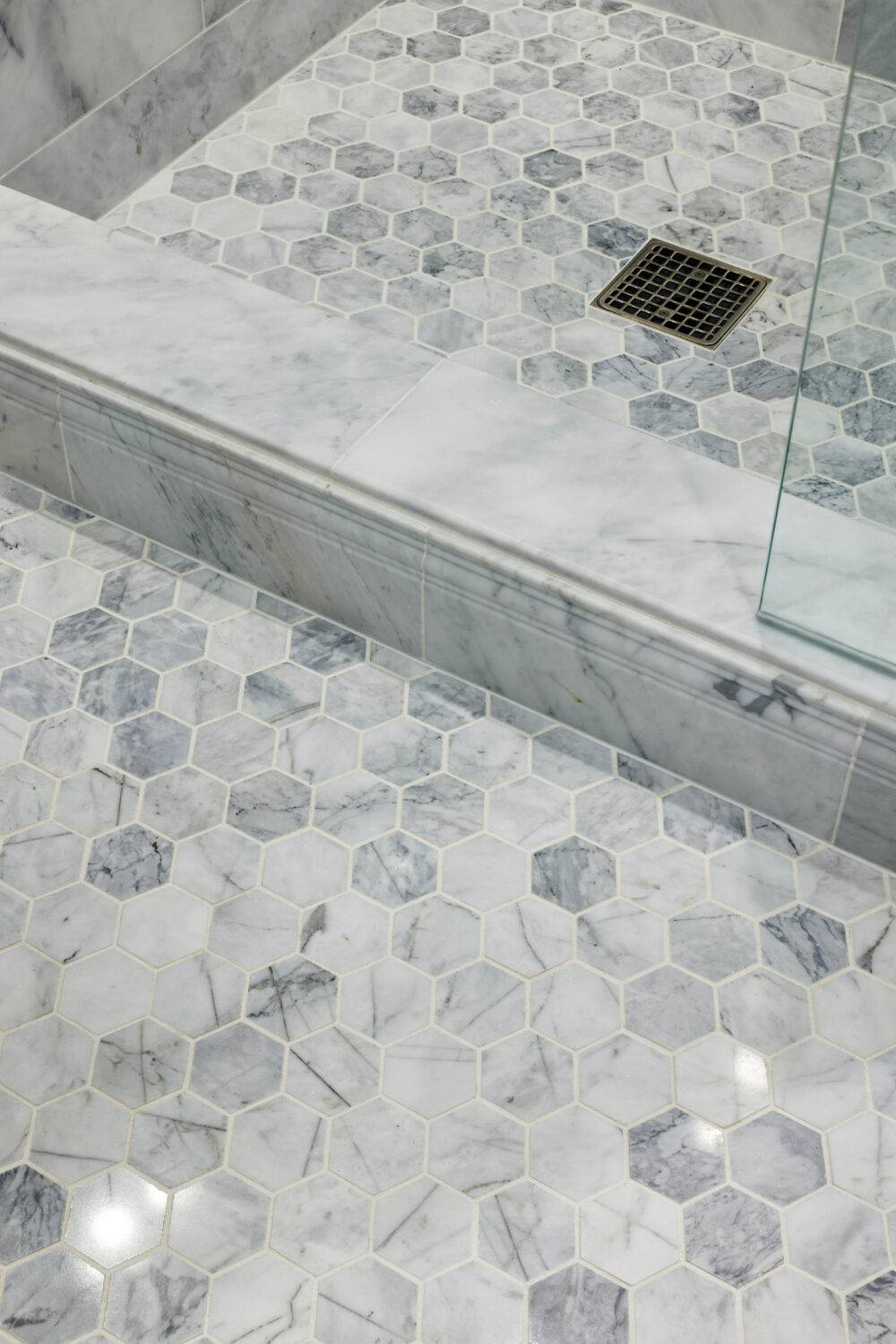 Shower floor with grey and white hexagon marble floor.