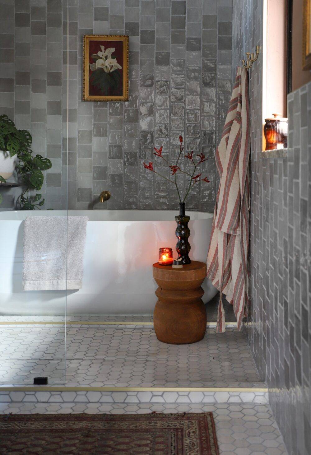 Grey handmade-look tile bathroom with marble hexagon tile floors. 