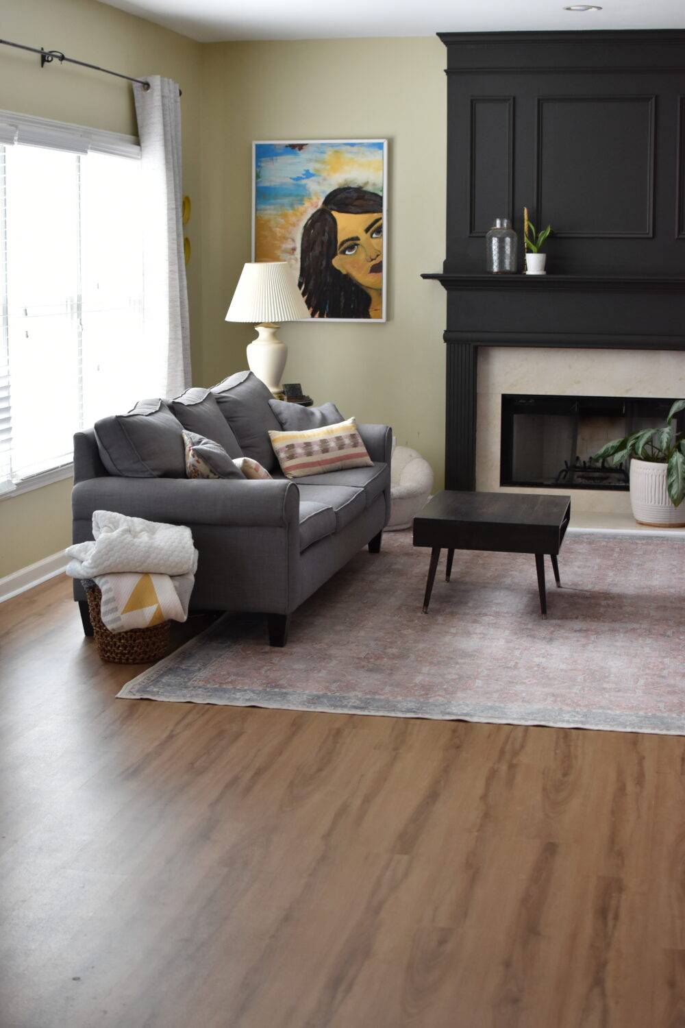 Living room with couch, coffee table and wood-look luxury vinyl tile. 