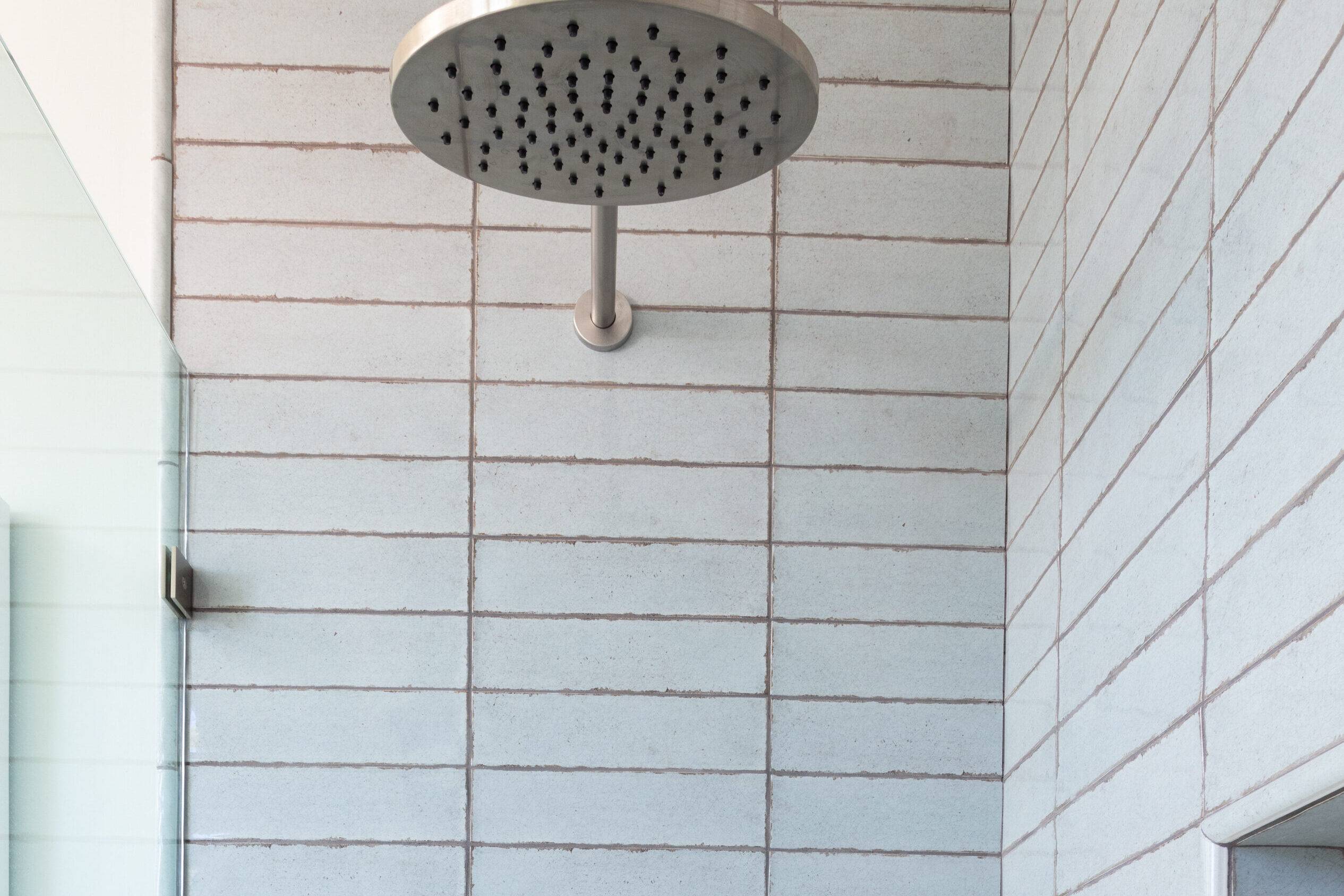 Shower with blue handmade-look stacked subway tile. 