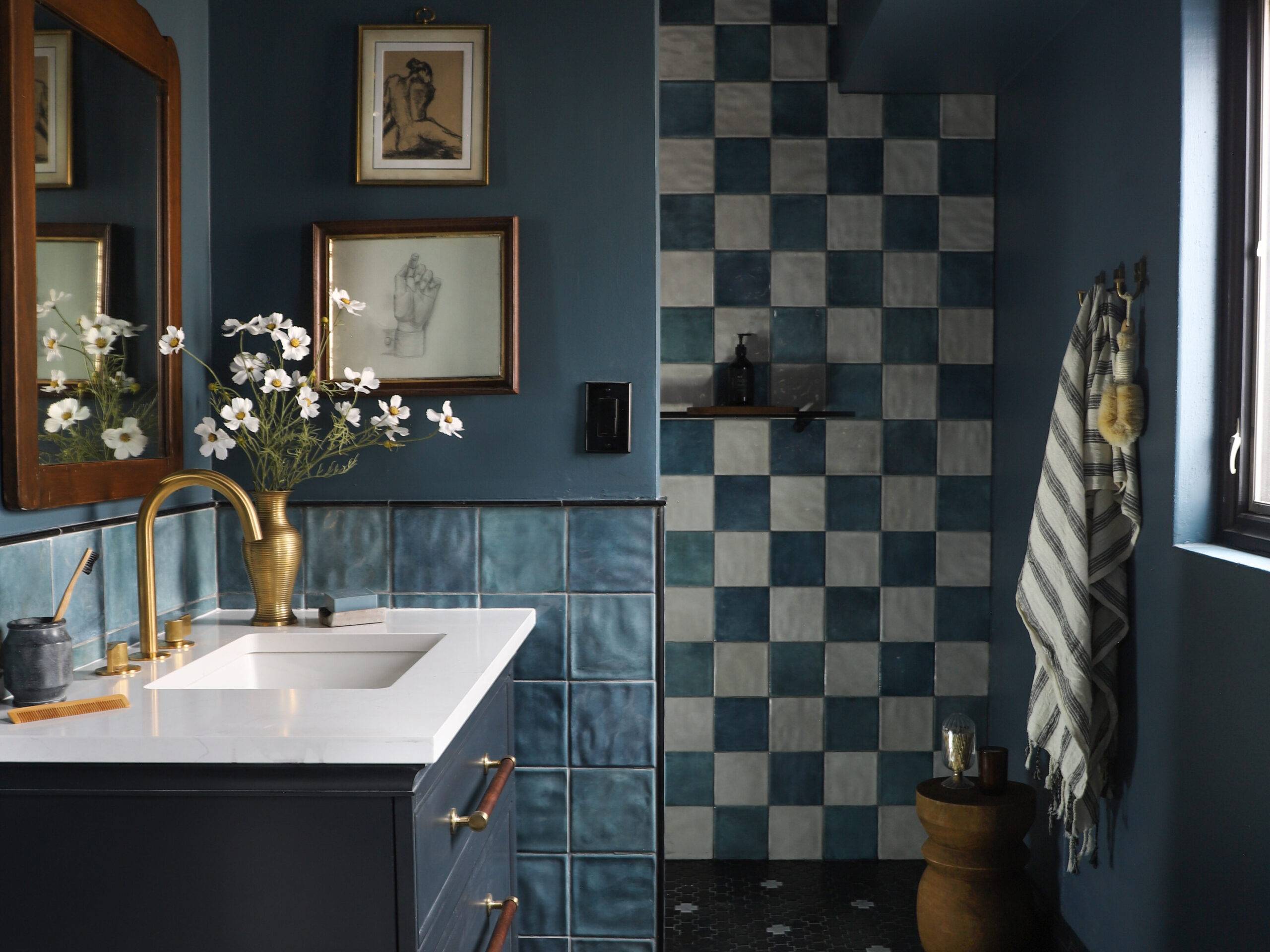 Blue bathroom with blue and white checkerboard handmade-look wall tile and black and white cross floor tile. 