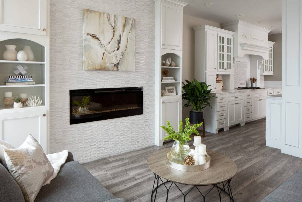 Living room and kitchen with wood look tile on floor.  White tile on backsplash in kitchen and textured stone on fireplace.