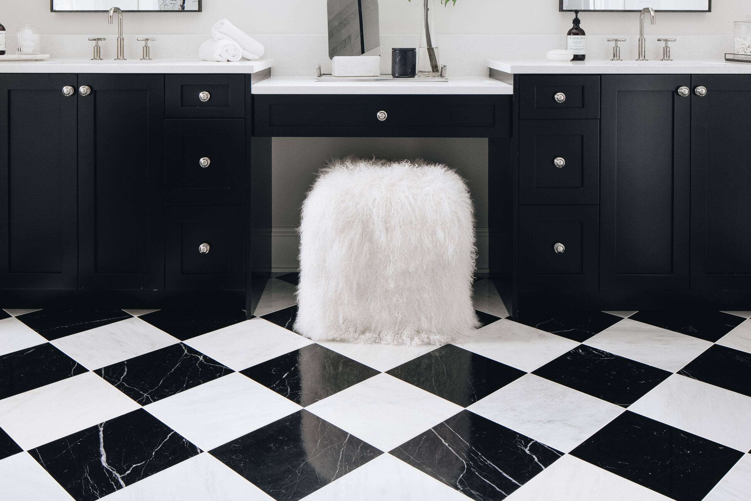 Black and white bathroom with black and white checkerboard marble floor. 