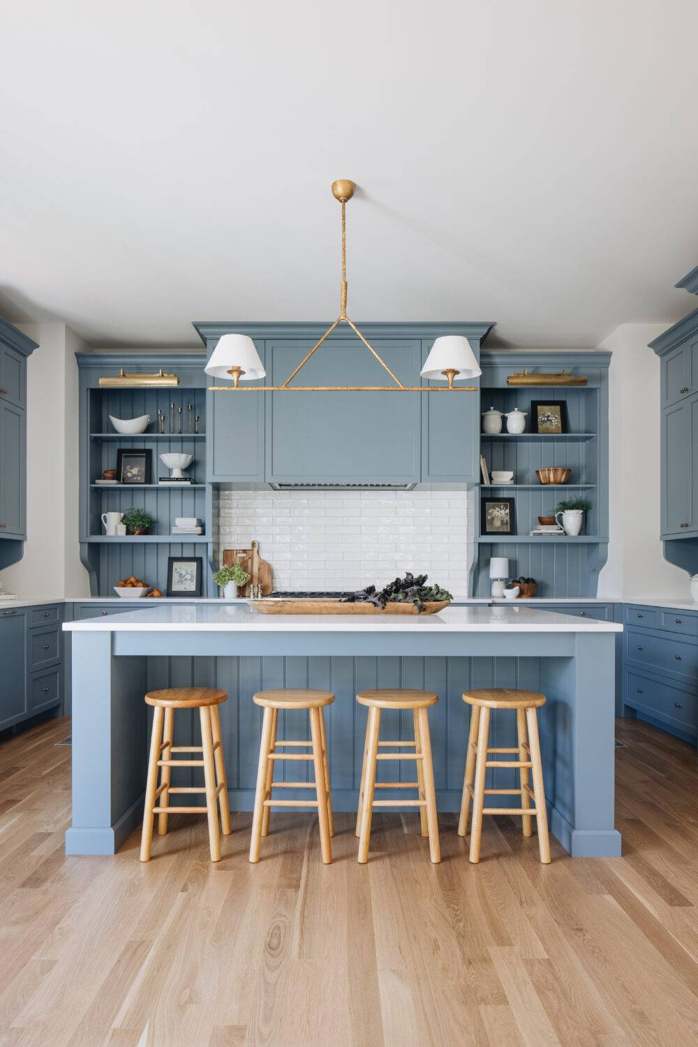 Kitchen with blue cabinets and white subway tile backsplash. 
