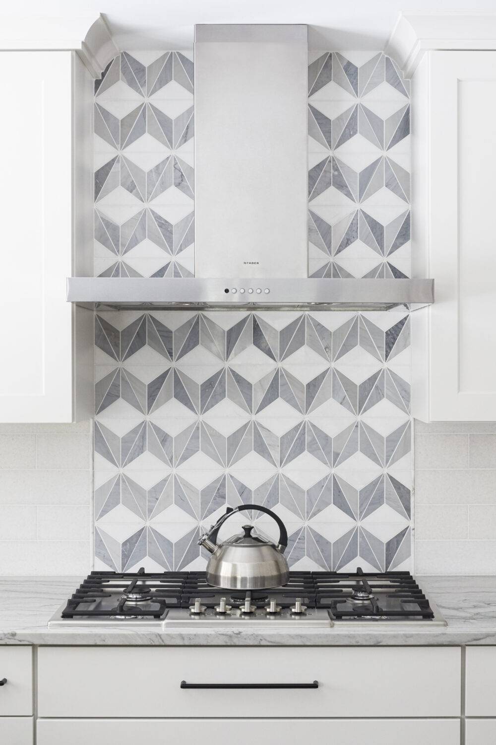 White and grey tile in a pattern kitchen stove backsplash.