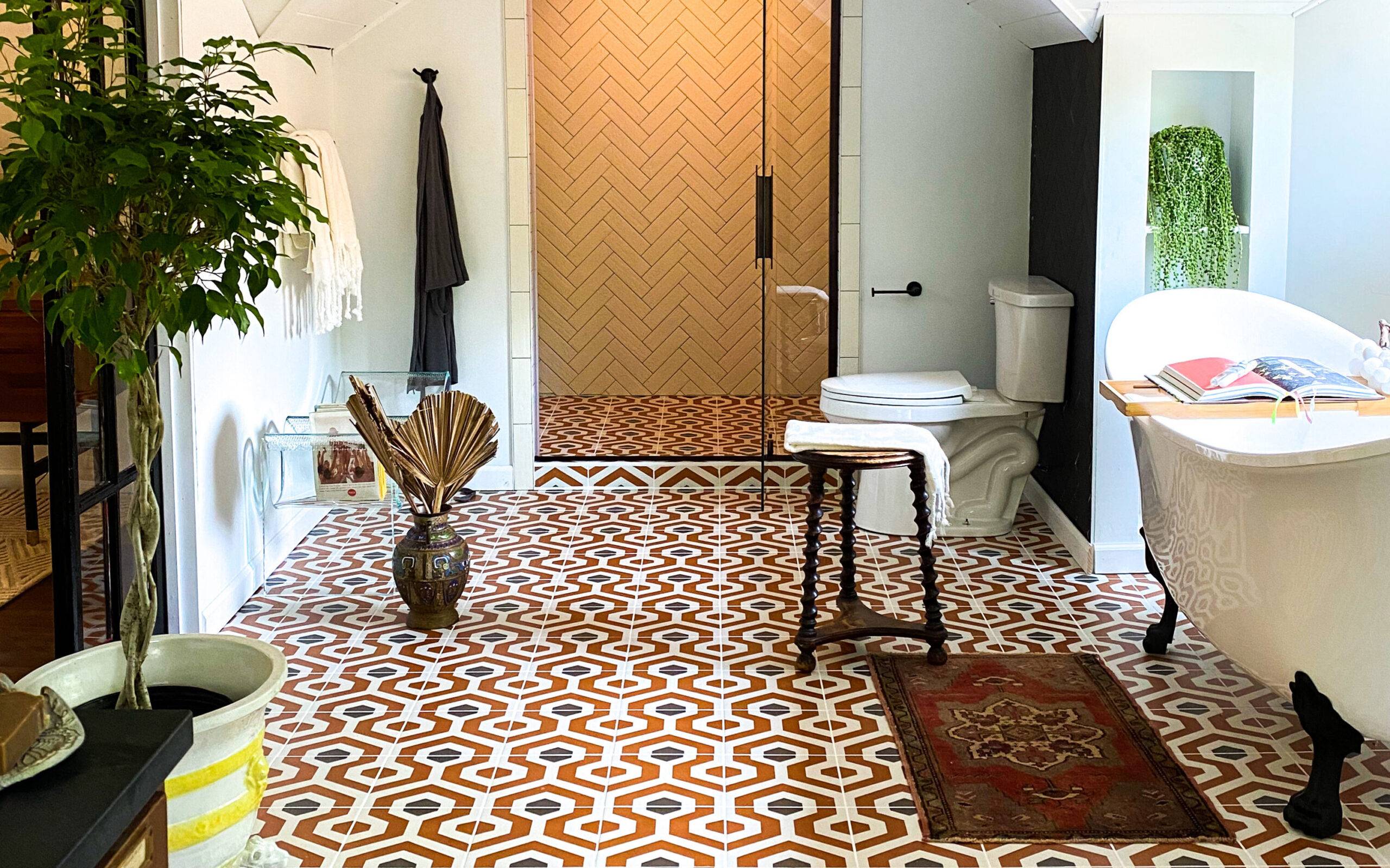 Bathroom with black, orange and off-white geometric patterned tile floor. 