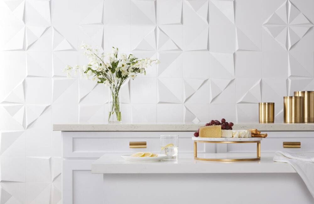 White kitchen cabinets with white 3-D tile wall. 
