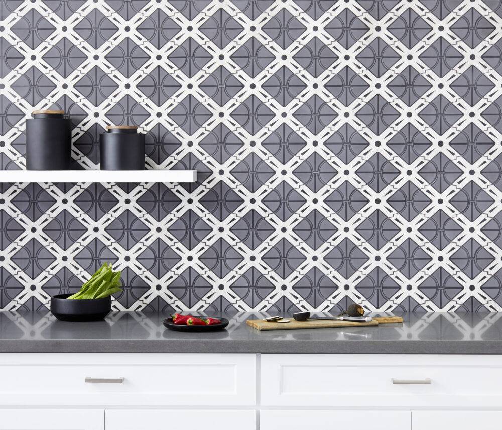 Kitchen backsplash using tile with a bold geometric design in black, grey and white is tempered by the soft, feminine arabesque shape.