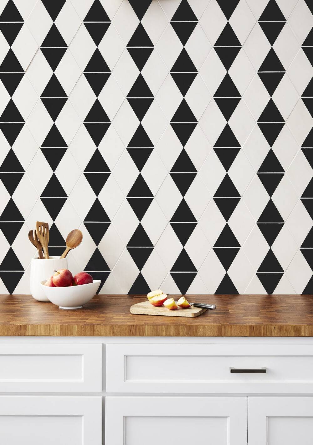 Kitchen with a chic black-and-white accent wall. With the diamonds and triangles on this hexagon tile it creates a woven geometric design. 