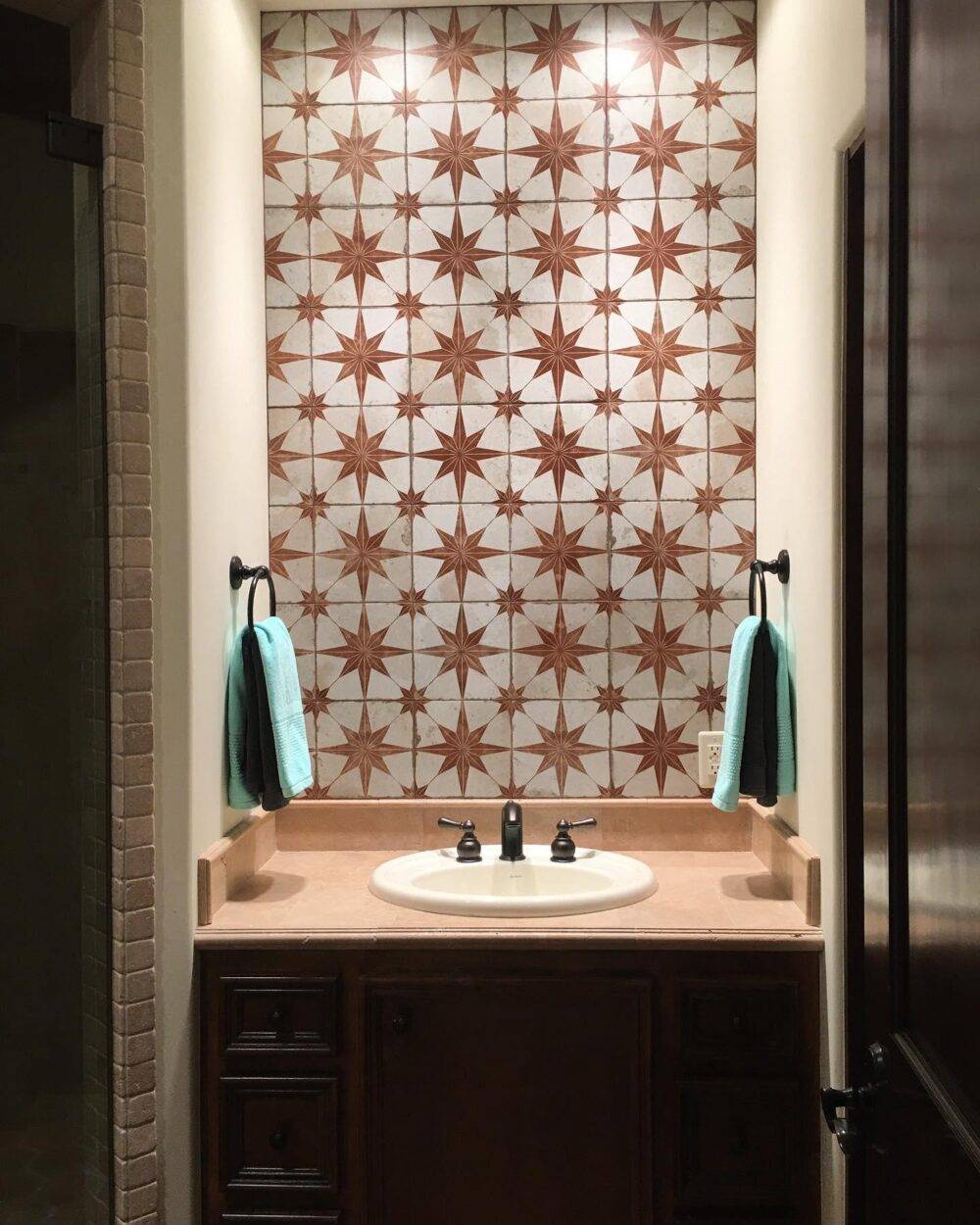 Sink area with orange star-patterned tile wall