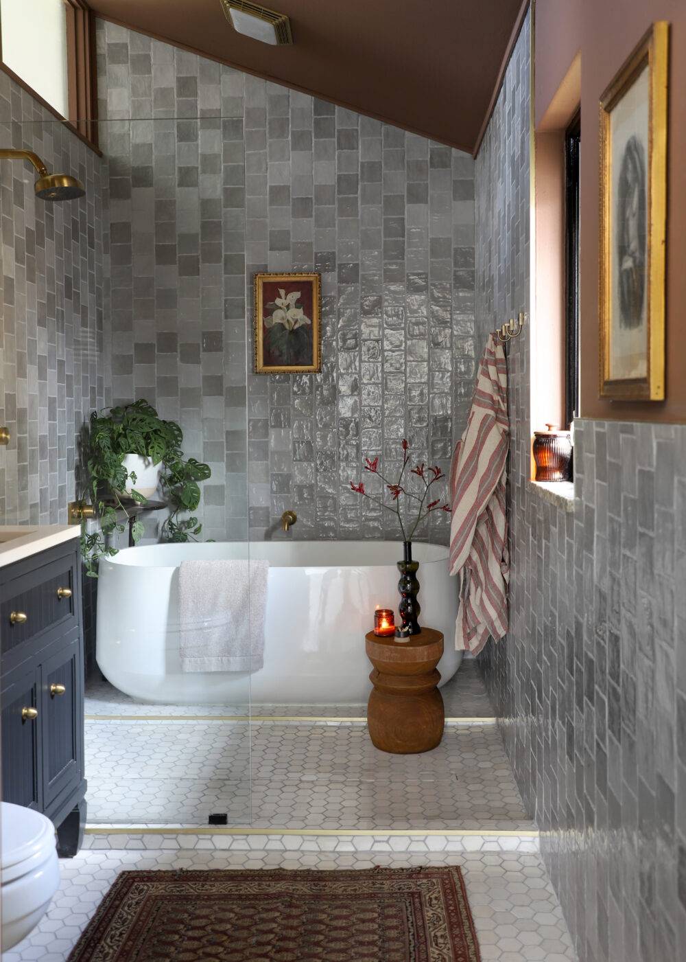 Luxurious bathroom with grey square handmade-look wall tiles and small marble hex floor tiles. 