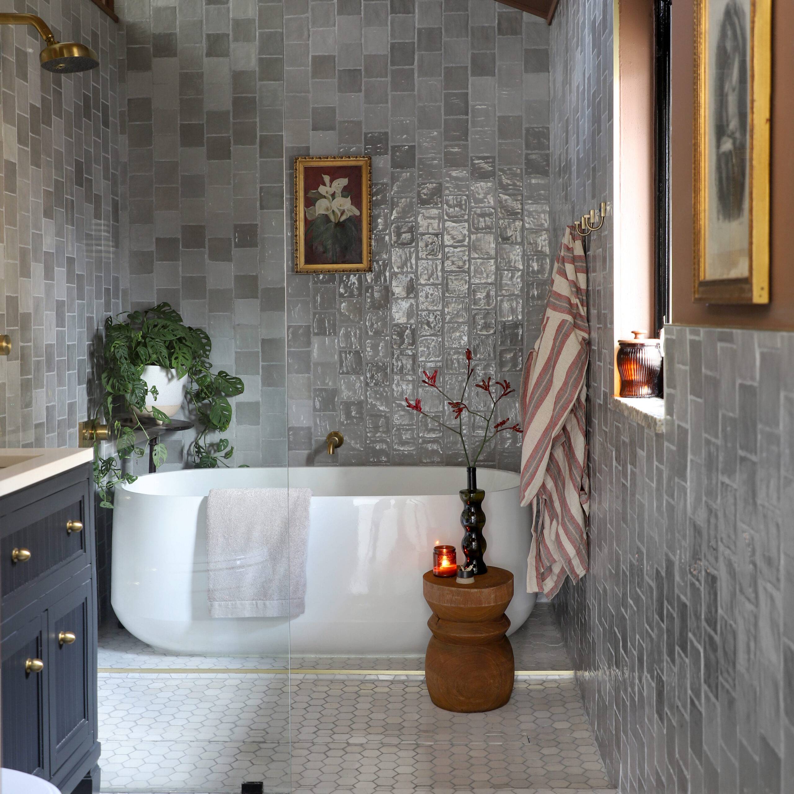 Bathroom with wet room, soaking tub, grey handmade-look tile walls and hexagon tile floor.