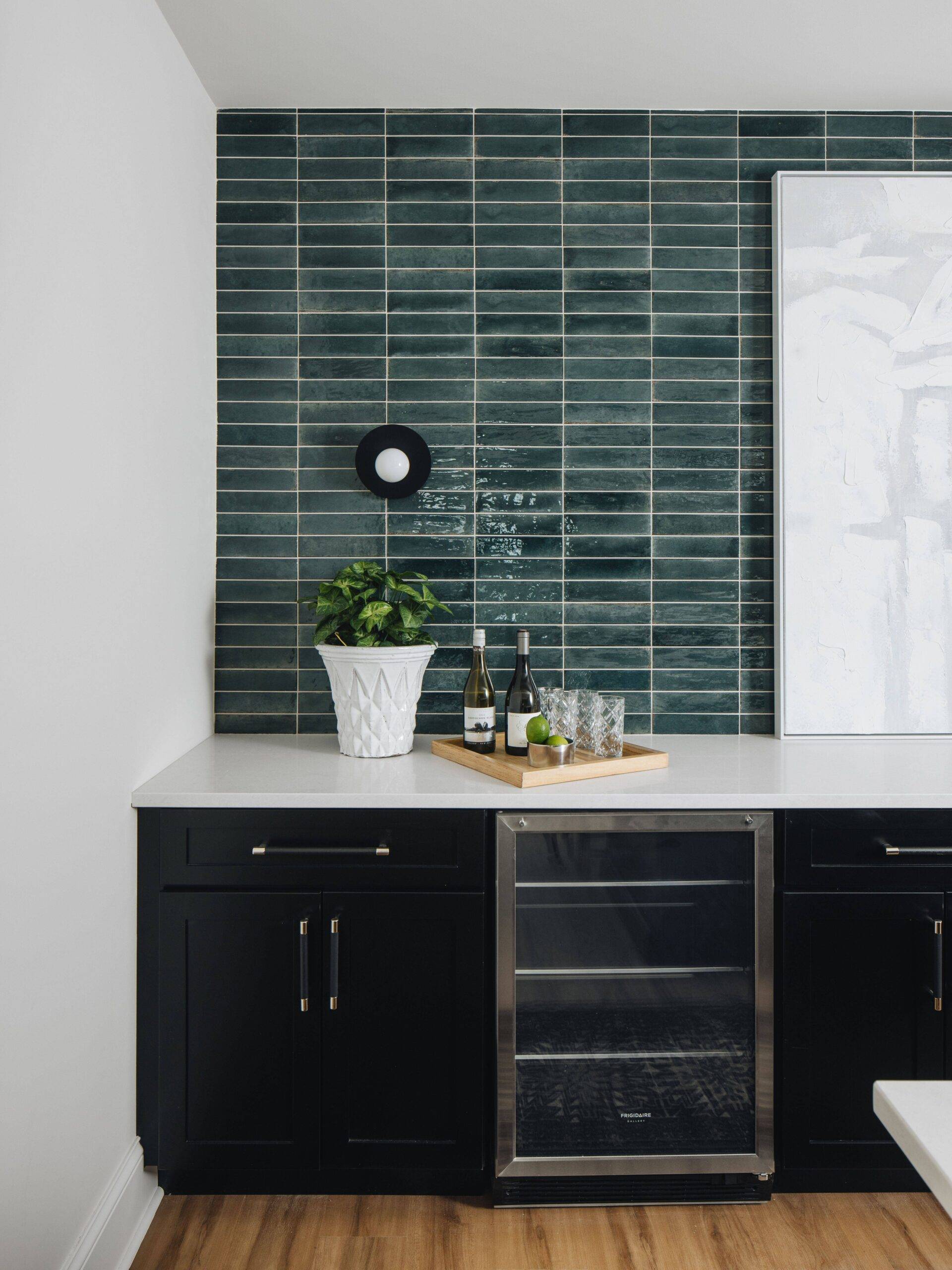 Bar area with green handmade-look vertical subway tile wall. 