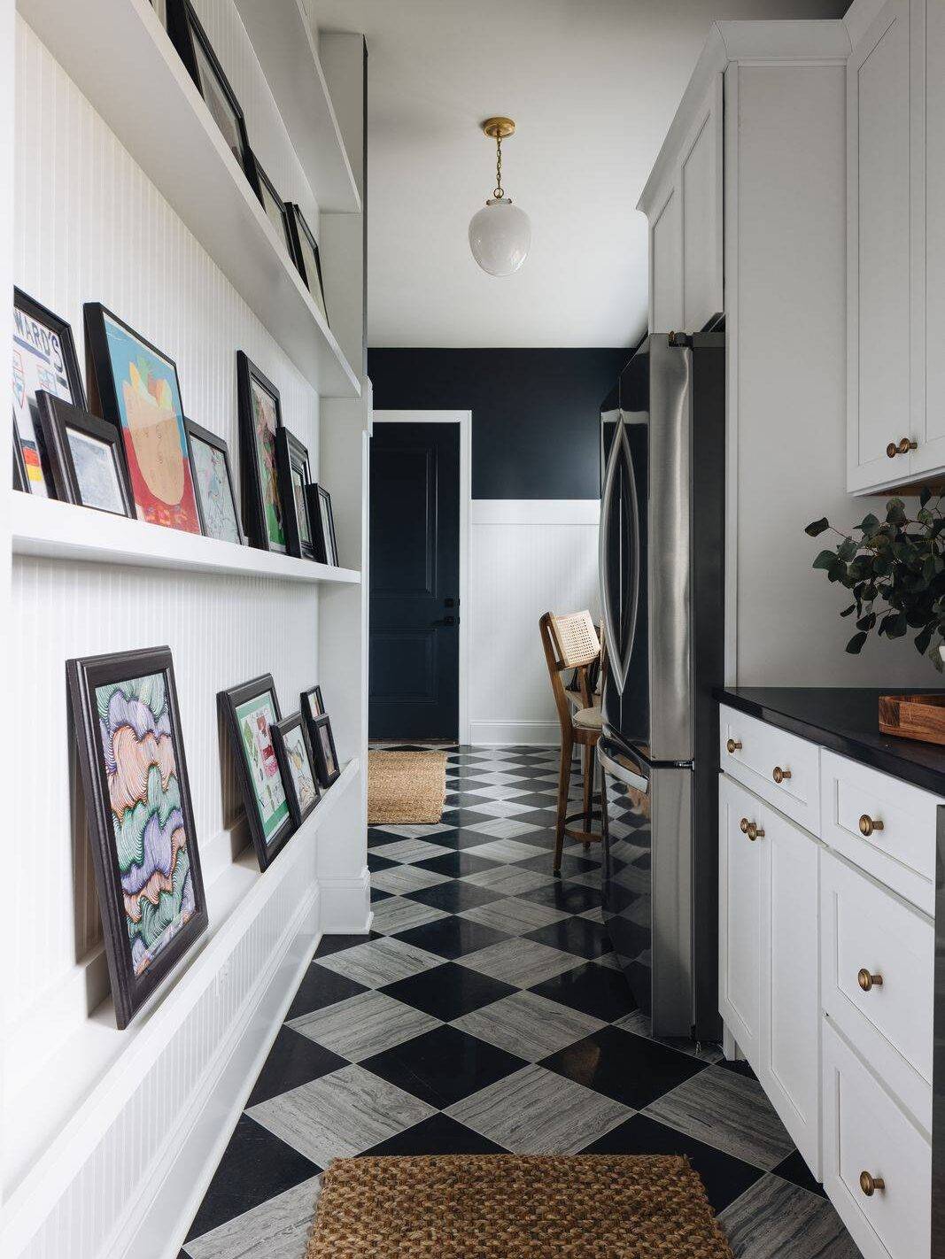 Mudroom with silver and black limestone checkerboard floor and pictures on the wall. 