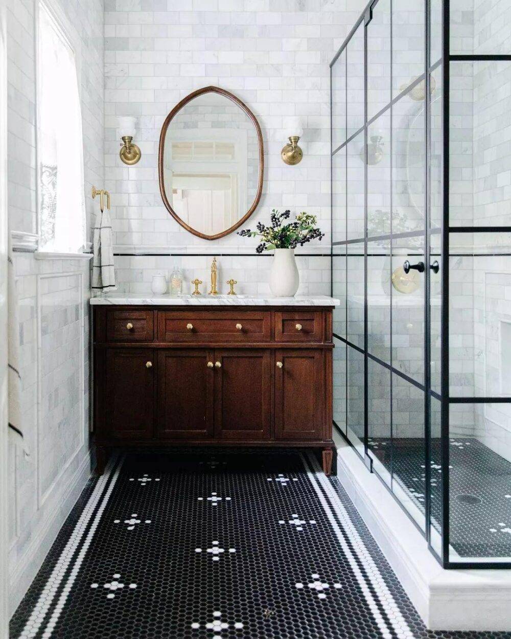 Colonial-style bathroom with marble subway tile walls and custom patterned black and white hexagon floor. 