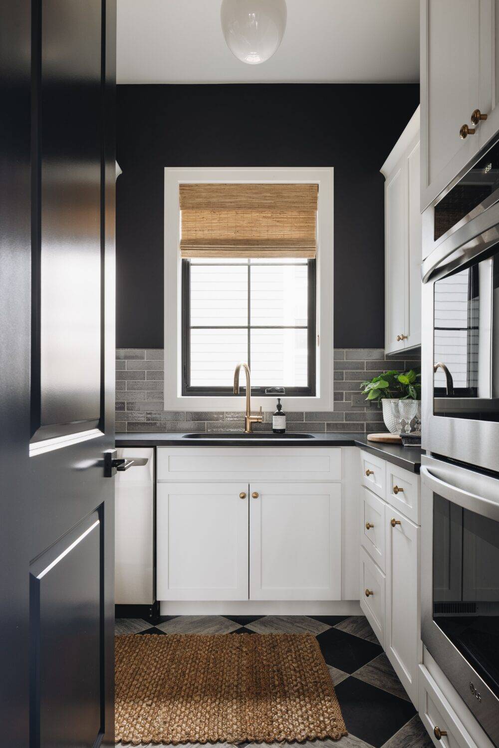 Pantry with sink, grey subway tile backsplash and black and silver limestone floor.