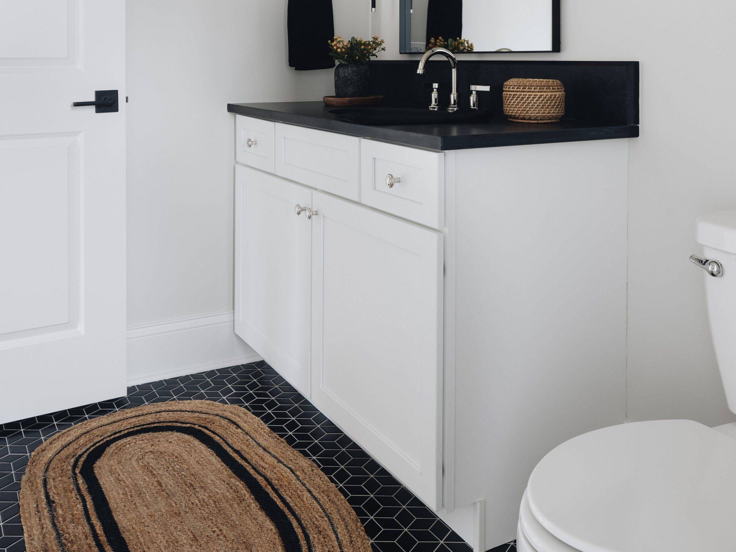 Bathroom with black rhombus patterned tile floor. 