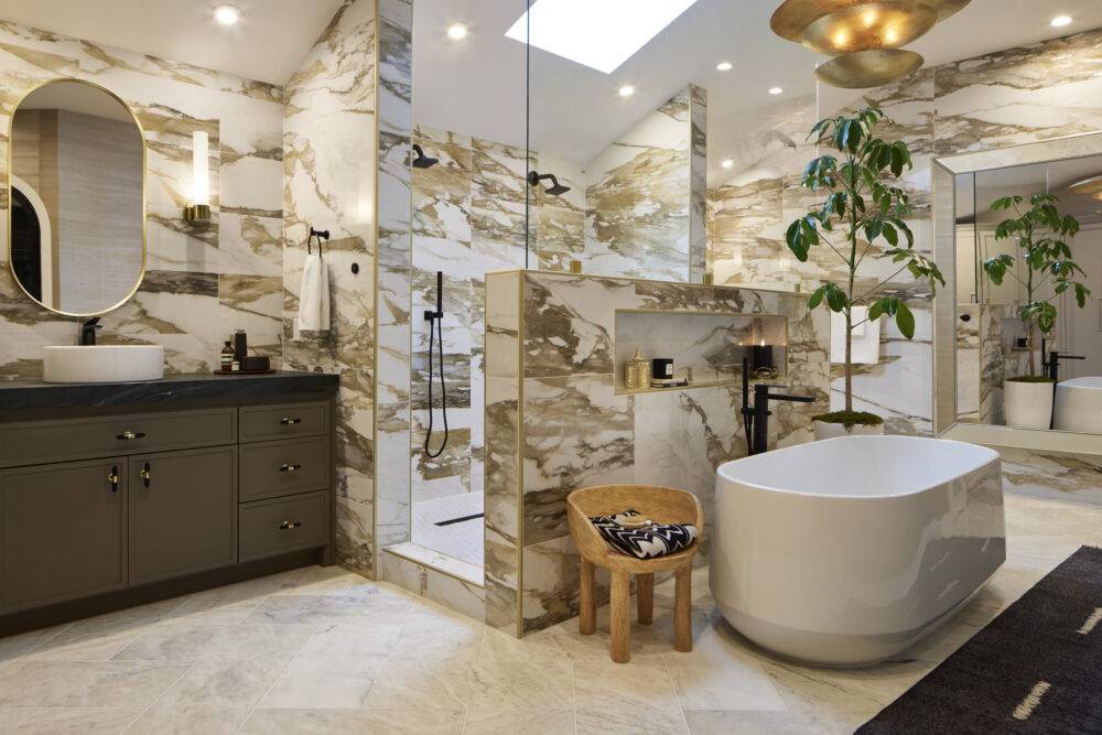 Bathroom with bold marble-look tiled walls and natural marble floor. 