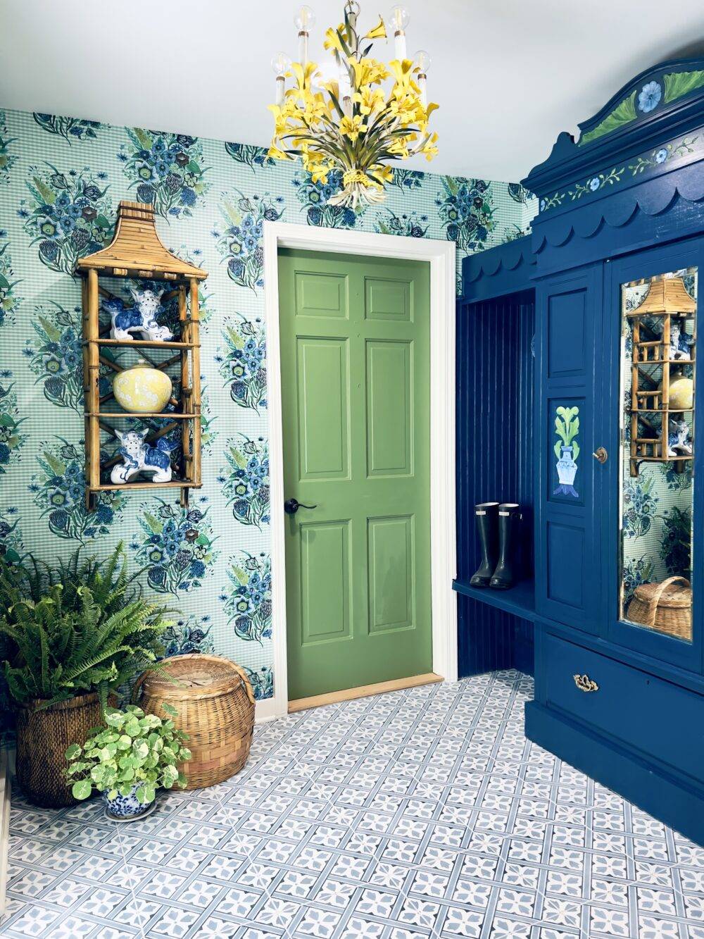 Bright blue and green entryway with blue floral patterned tile floor. 