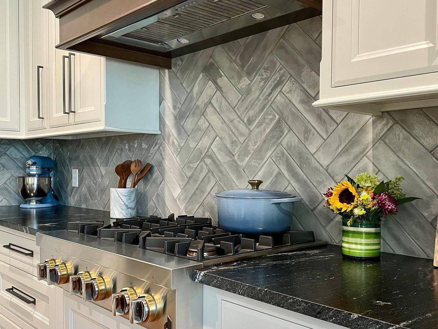 Grey subway tile kitchen backsplash in double herringbone pattern.