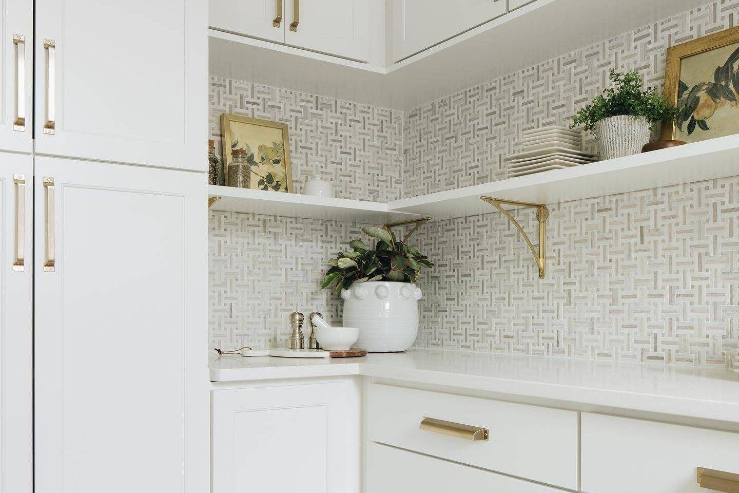 White and tan basketweave mosaic tile backsplash with white kitchen cabinets. 