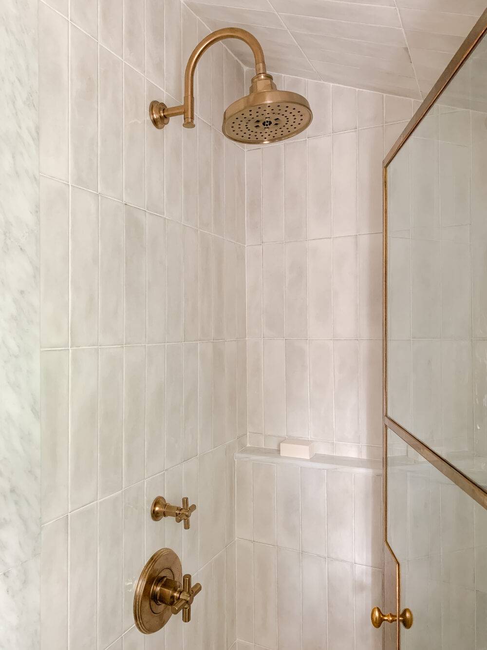 Shower with white handmade-look vertical stack subway tile.