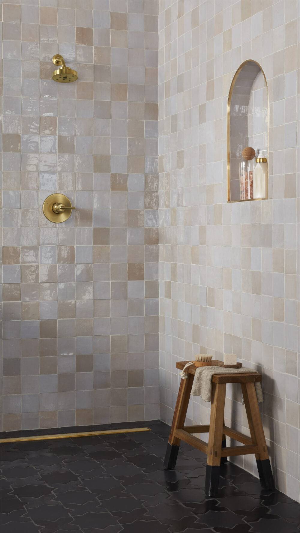 Shower with square handmade wall tiles and black cross and star handmade floor tiles. 