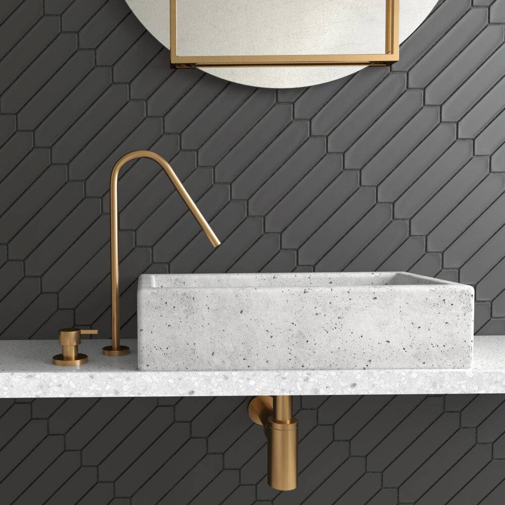 This bathroom features a modern sink and black picket tile. 