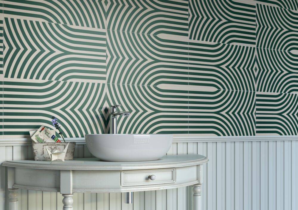 Geometric patterned green and off-white bathroom tile with sink.