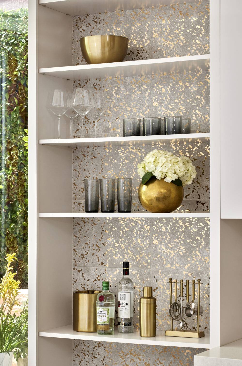 Gold speckled white tile backsplash with bar shelves.