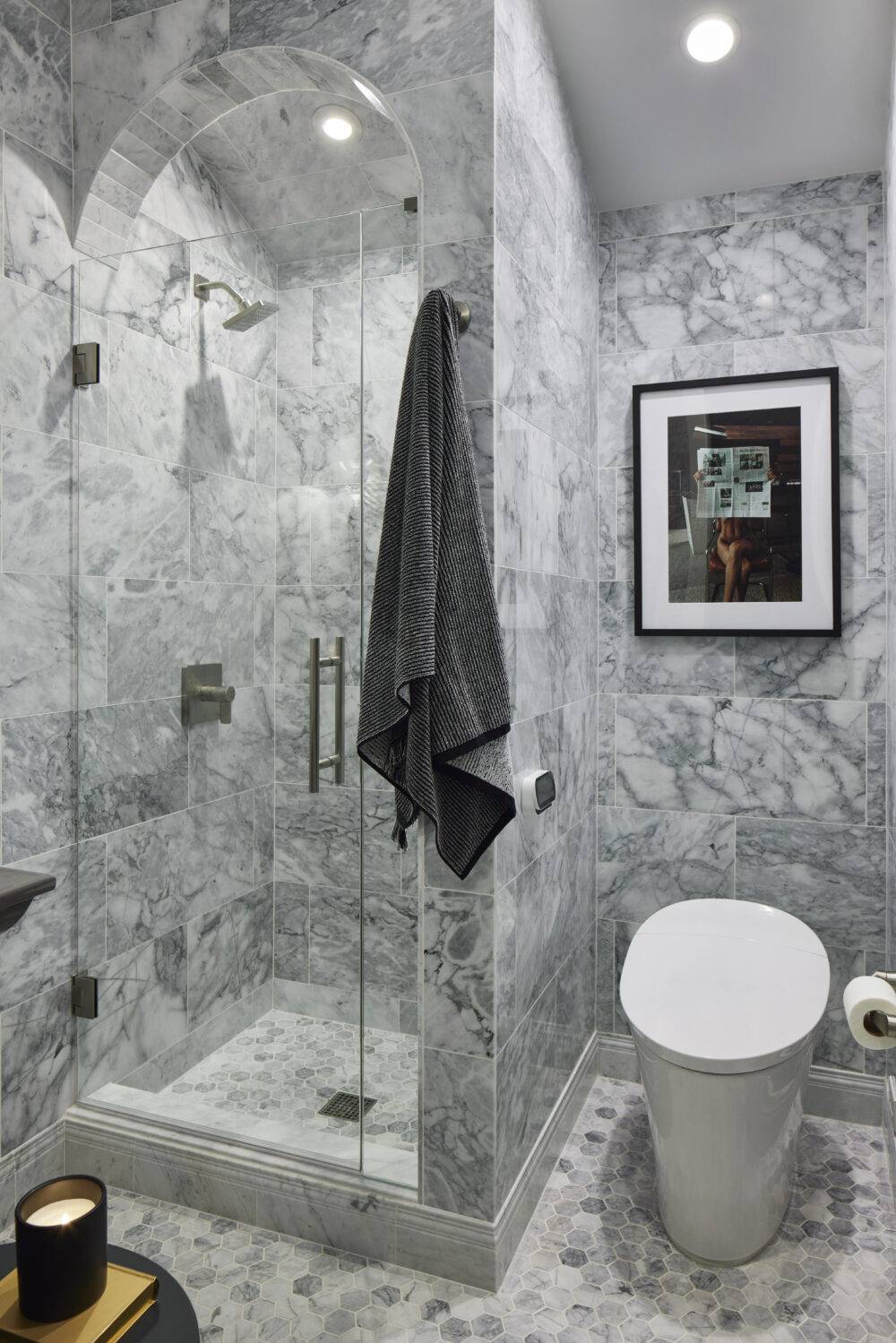 Grey marble bathroom with shower and painting.
