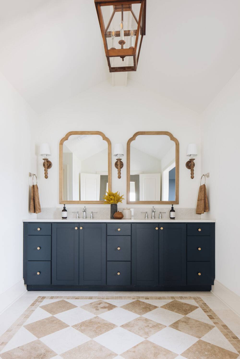 Bathroom with white and cream checkerboard patterned floor and blue sink vanity.