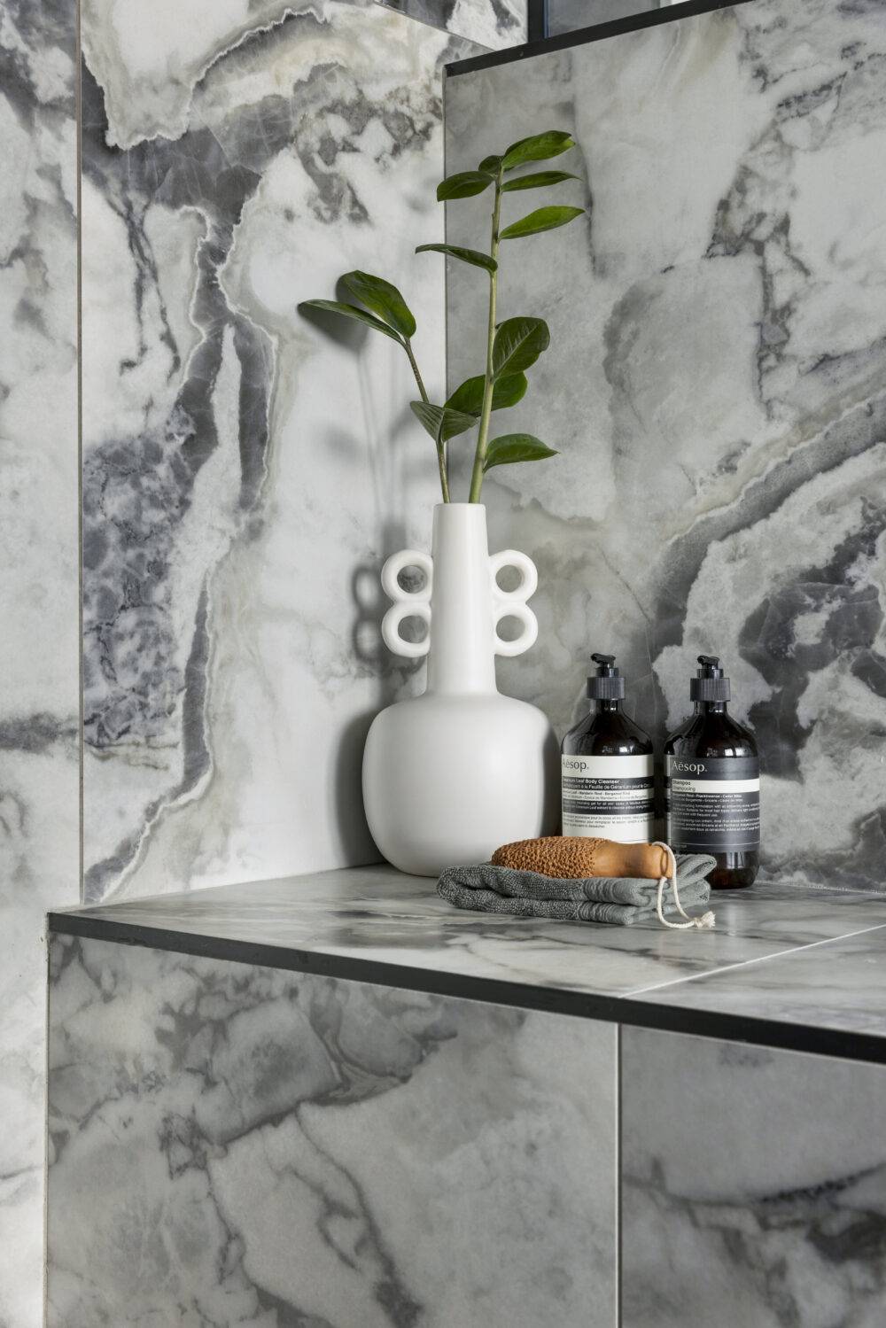 This modern bathroom features stunning grey large-format marble-look tile with bold dark grey veining. 