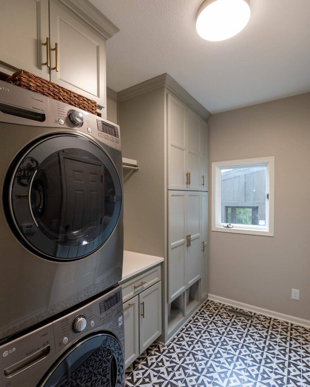 This laundry room features a black and white marble patterned tile floor.