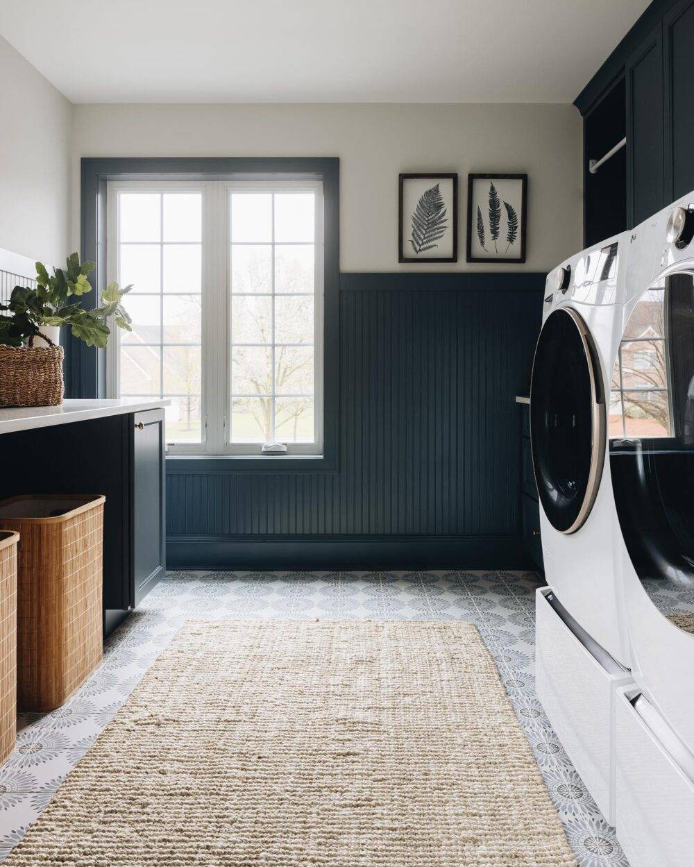 A laundry room with a geometric floral patterned floor tile. 