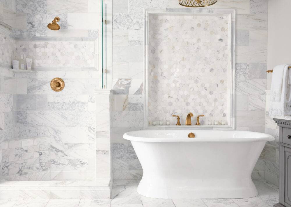 Italian marble has a polished finish and displays a cloudy white base with gold veining, providing these bathroom walls and floors with elegance.