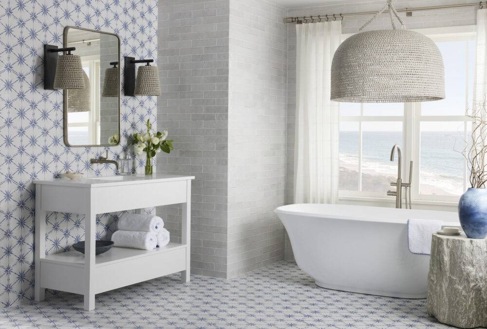 Coastal chic bathroom featuring blue and white patterned hexagon tile and light grey handmade-look subway tile. 