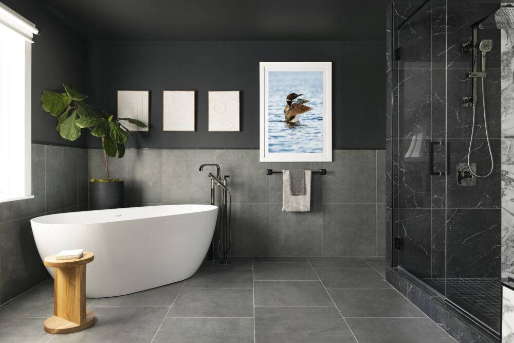 This modern bathroom features large-format grey floor and wall tile and dark grey with white veining shower tile. 