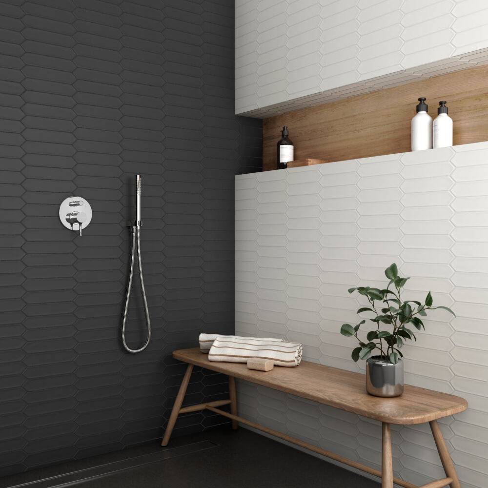 This large, open shower features a black picket tile wall and a white picket tile wall.