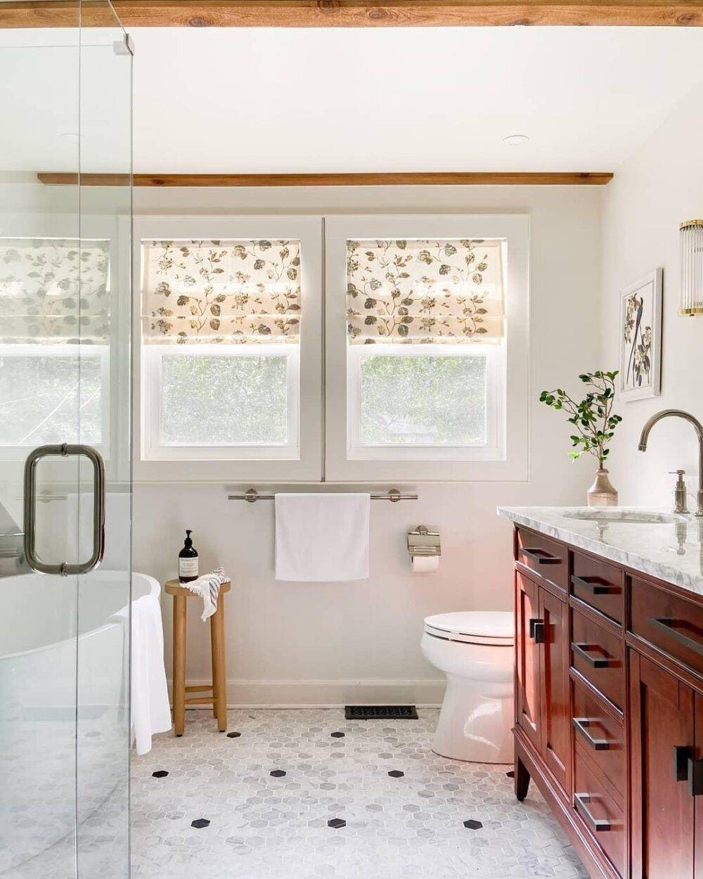 Bathroom with dark-wood sink vanity, mirror, plant and lots of natural light.