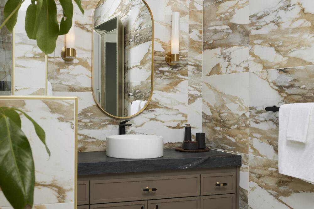 Sink vanity with mirror. White tile with brown veining.