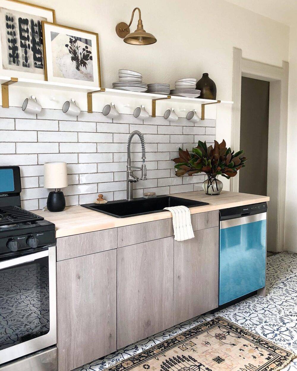 This small kitchen features a white handmade-look subway tile backsplash and boho-inspired patterned tile floor. 