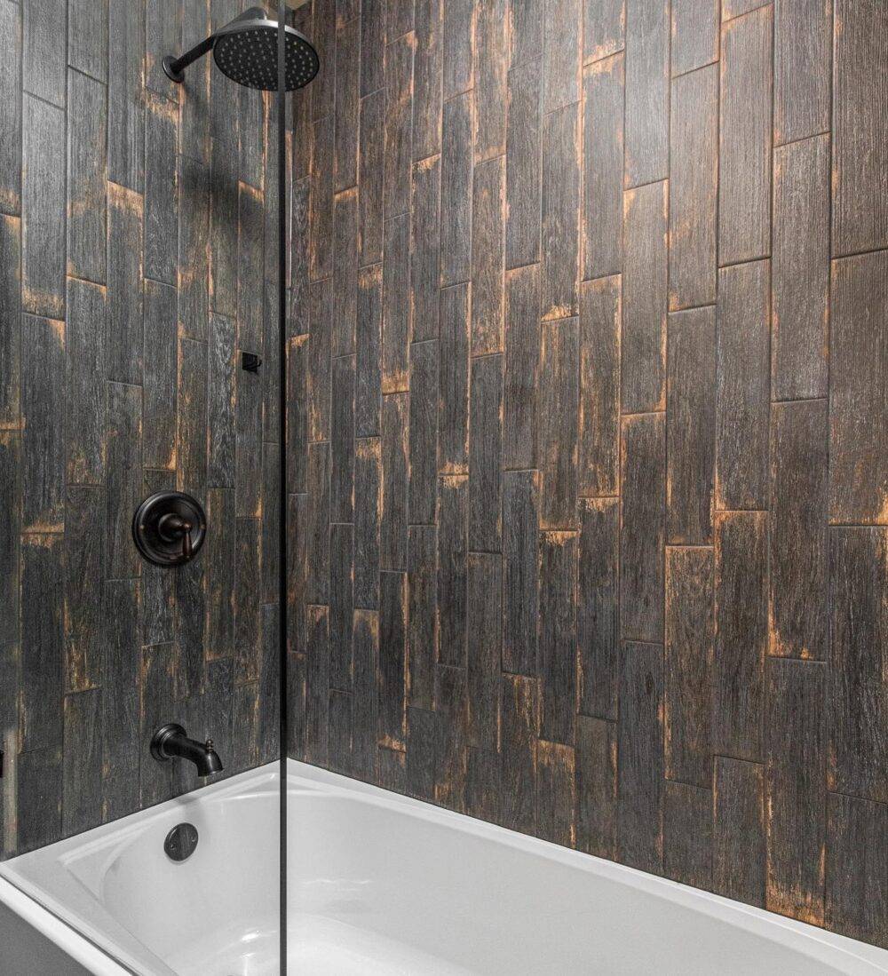Dark black wood-look shower tile wall. 