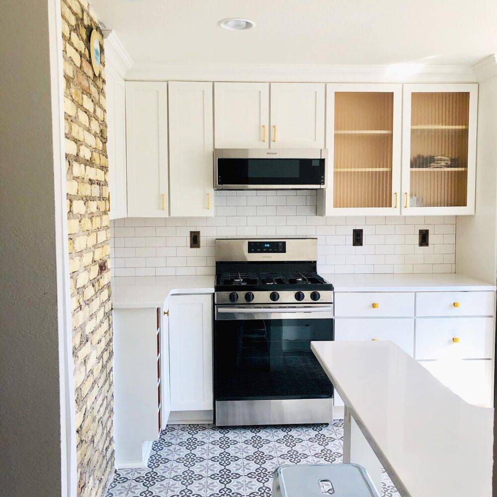 This small kitchen features patterned encaustic-look tile floor and a white subway tile backsplash. 